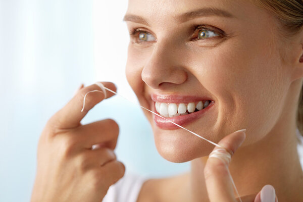 Teeth Care. Beautiful Smiling Woman Flossing Healthy White Teeth