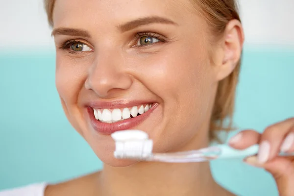 Hermosa mujer sonriente cepillando sanos dientes blancos con cepillo — Foto de Stock