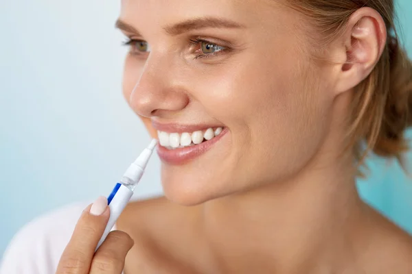 Dientes blancos sanos. Hermosa mujer sonriente usando pluma blanqueadora — Foto de Stock