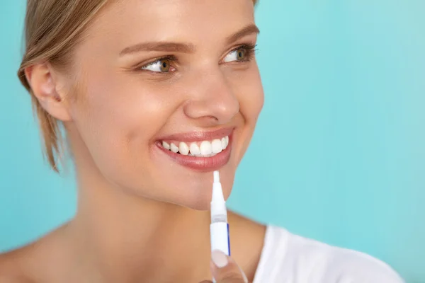 Жінка з прекрасною посмішкою, здорові зуби, використовуючи відбілюючу ручку — стокове фото