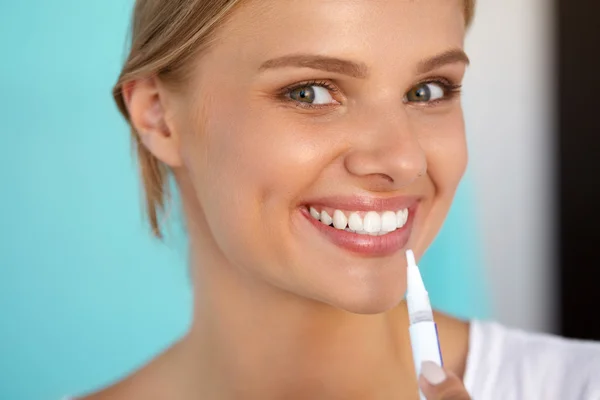 Mujer con hermosa sonrisa, dientes sanos usando pluma blanqueadora — Foto de Stock