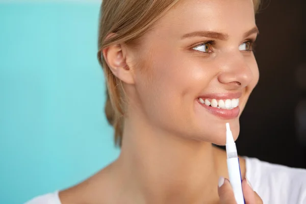 Mujer con hermosa sonrisa, dientes sanos usando pluma blanqueadora — Foto de Stock