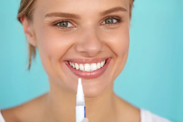 Egészséges fehér fogak. Gyönyörű mosolygó nő használata Whitening Pen — Stock Fotó