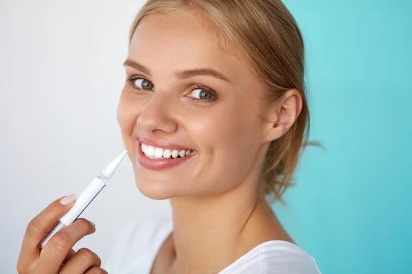 Sbiancamento dei denti. Bella donna utilizzando denti penna sbiancante — Foto Stock