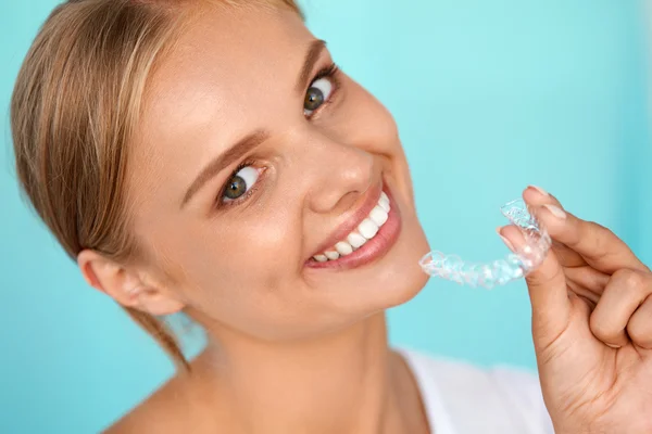Mulher sorridente com dentes brancos segurando dentes branqueamento bandeja — Fotografia de Stock