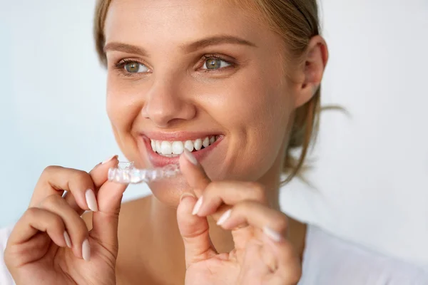 Lachende vrouw met mooie glimlach met behulp van tanden whitening tray — Stockfoto