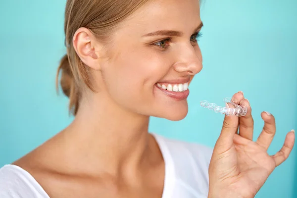 Mujer sonriente con dientes blancos sosteniendo bandeja blanqueadora de dientes — Foto de Stock