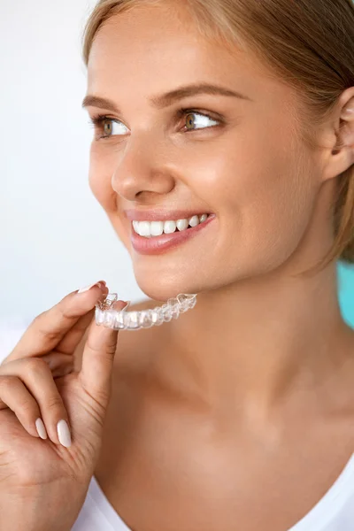 Χαμογελαστή γυναίκα με όμορφο χαμόγελο χρησιμοποιώντας δόντια λεύκανση δίσκο — Φωτογραφία Αρχείου