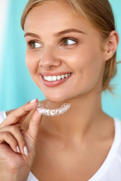 Lachende vrouw met mooie glimlach met behulp van tanden whitening tray — Stockfoto