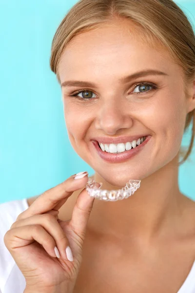 Mulher sorridente com sorriso bonito usando dentes branqueamento bandeja — Fotografia de Stock