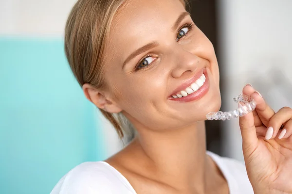 Femme souriante avec dents blanches tenant plateau de blanchiment des dents — Photo