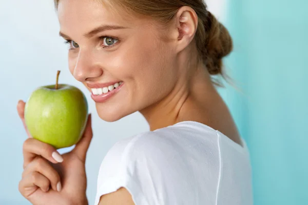 快乐的女人与美丽的微笑，健康的牙齿拿着苹果 — 图库照片