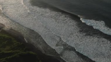 Endonezya kıyılarına düşen okyanus dalgalarının hava görüntüsü. Güneşli bir günde Mavi Suyla Deniz Kısaltması.