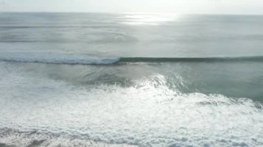 Endonezya kıyılarına düşen okyanus dalgalarının hava görüntüsü. Güneşli bir günde Mavi Suyla Deniz Kısaltması.