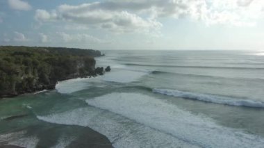 Endonezya 'nın Bali kentindeki bir grup sörfçünün hava görüntüsü. Çarpan Dalgalarda İnsanlar Sörf Yapıyor.