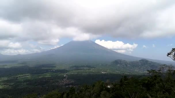 Vista aérea del monte Agung en las nubes en Bali, Indonesia. Paisaje maravilloso cerca del volcán, sombras de nubes en movimiento en Green Valley en Asia. — Vídeos de Stock
