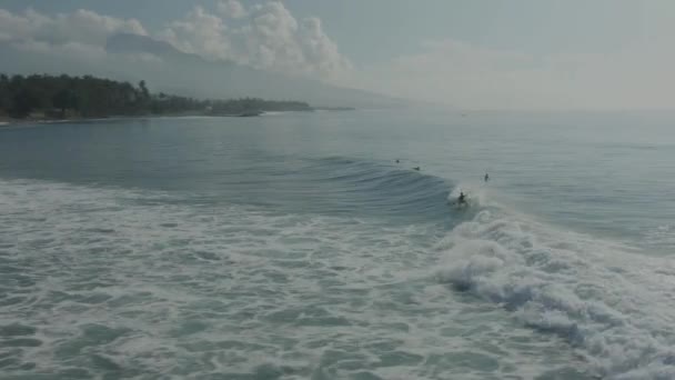 インドネシアのバリでの海でのサーファーのグループの空中ビュー。波に乗り込む人々. — ストック動画