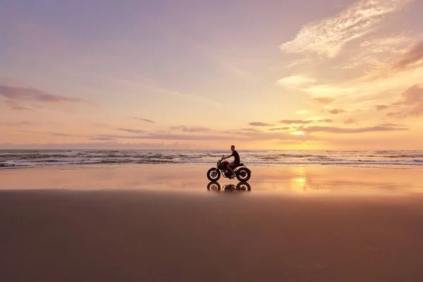 Man en motor op Ocean Beach bij mooie tropische zonsondergang. Motorrijder Silhouet Op Motorfiets Aan Zandkust Aan Zee In Bali, Indonesië. — Stockfoto