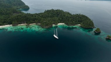 Triton Körfezi 'nin Havadan Görünümü, Raja Ampat Adaları, Turkuaz Suyu ve Yeşil Tropikal Ağaçlı Gölde Tekne. Geniş Açı Doğa: Pasifik Okyanusu ve Endonezya Papua 'da Çarpıcı Manzara.