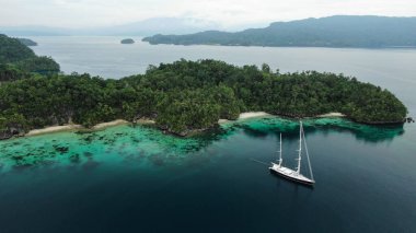 Raja Ampat Adalarındaki Triton Körfezi Turkuaz Denizi 'ndeki Tekne ve Yeşil Tropikal Ağaçlar. Geniş Açı Doğanın Havadan Görünümü, Pasifik Okyanusu ve Resimli Manzara Papua, Endonezya.