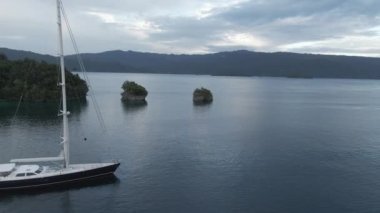 Kri Adası 'ndaki güzel okyanus, Raja Ampat. Turkuaz Denizi 'ndeki Sandy Sahili' nden Papua, Endonezya 'daki Vahşi Topraklara İHA yaklaşıyor..