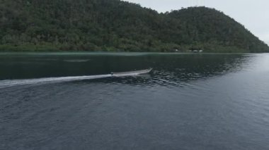 Kaimana Adaları 'ndaki Triton Körfezi' nde su sıçratan teknenin hava görüntüsü. Endonezya, Papua 'da Su Sanatı ile Geniş Açı Çekimi.