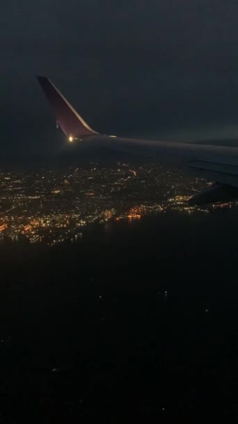 夜航飞机在黑暗的天空中飞越云彩 从飞机窗口看美丽景色的垂直视频 云彩背景下的翼拍 — 图库视频影像