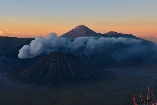 Solnedgång bakom rökiga vulkanen berg, Indonesien — Stockfoto