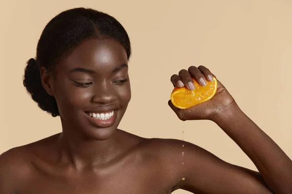 Portret Zbliżenie Pięknej Afrykańskiej Dziewczyny Naciskając Plasterek Pomarańczy Kroplami Uśmiechnięta — Zdjęcie stockowe