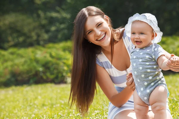 Matka a dítě sedět na trávě — Stockfoto