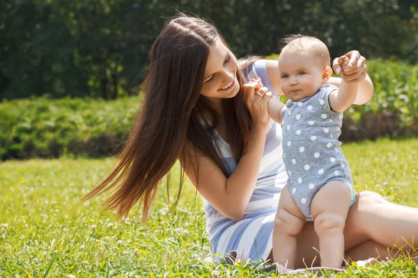 Matka a dítě sedět na trávě — Stockfoto