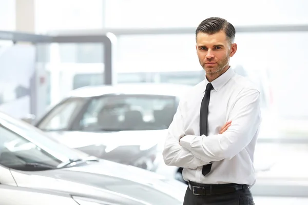 Säljare står i bil butik. Bil Showroom. — Stockfoto