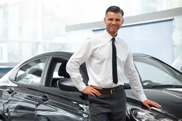 Vendedor se para cerca de nuevo coche . — Foto de Stock