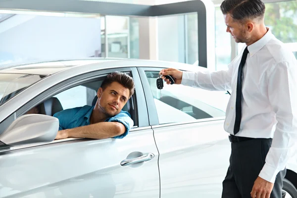 Carro vendedor entregando novo carro chave para o cliente — Fotografia de Stock