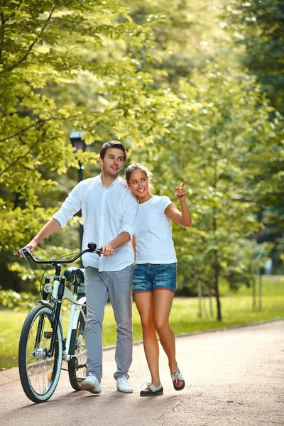 Happy Couple with bicycle in park. — Stock Photo, Image