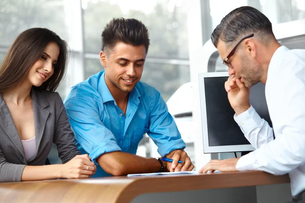 Un couple signe un contrat pour l'achat d'une nouvelle voiture — Photo