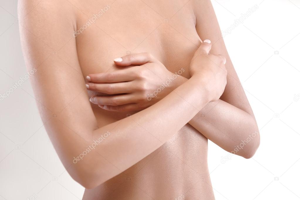 woman checking breast for signs of cancer