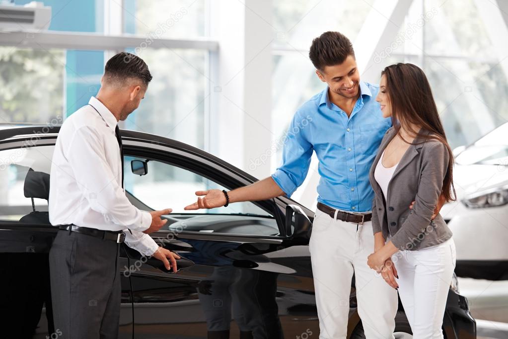 Car Salesman Invites Customers at Showroom.