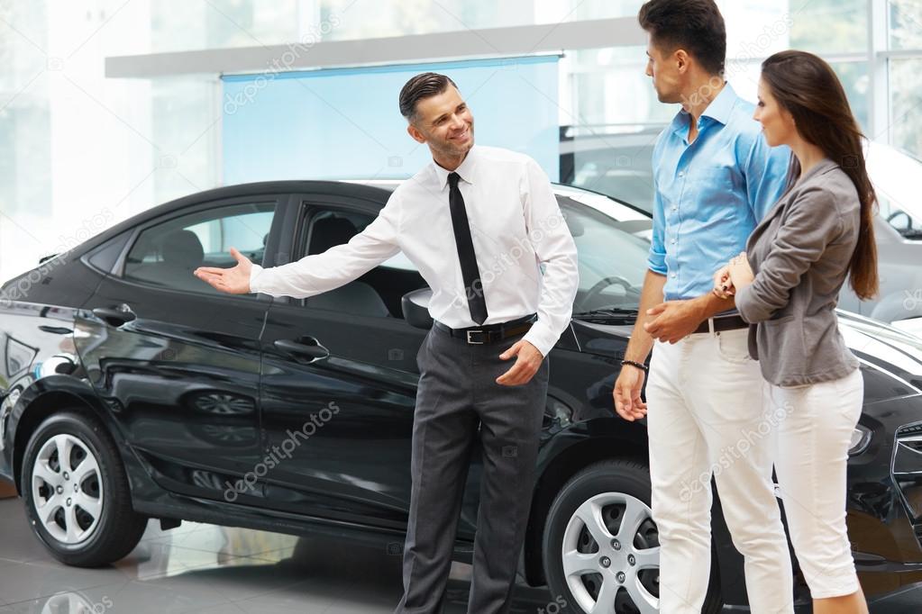 Car Salesman Invites Customers at Showroom.