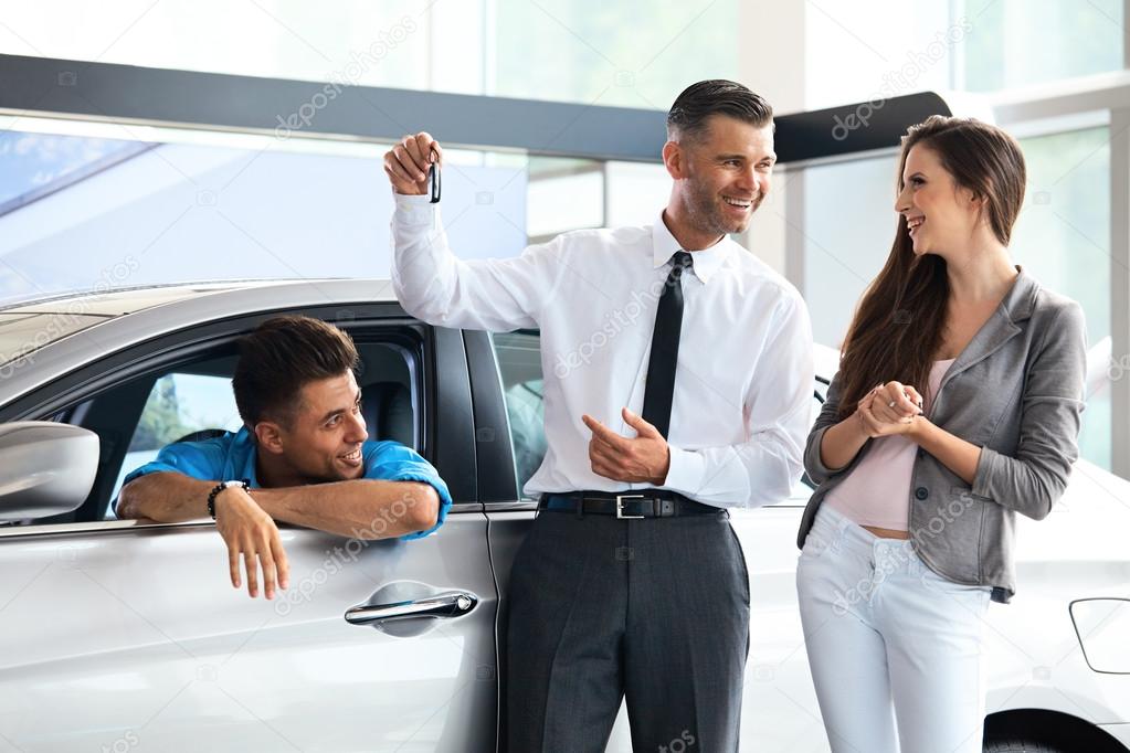 Car Salesman Giving a Key From the New Car
