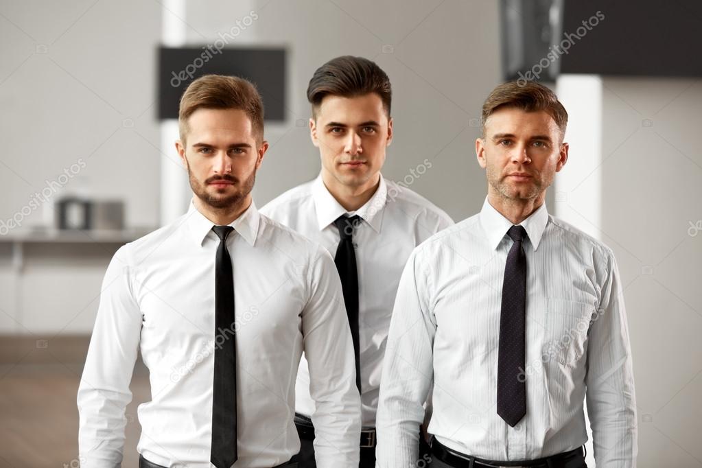 Three businessmen standing in office