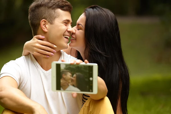 Pareja feliz tomando autorretrato en el parque. Tableta digital — Foto de Stock