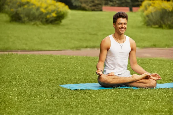 Yoga Exercise. Portrait of athletic man doing a yoga at summer p — Stock Photo, Image