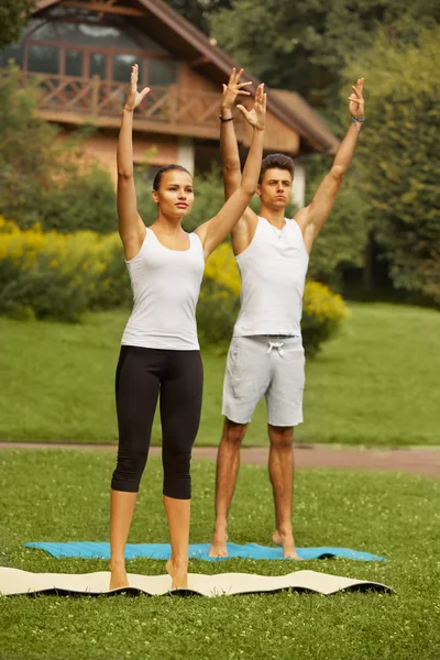Exercício de Yoga. Jovem casal meditando no clube de fitness — Fotografia de Stock