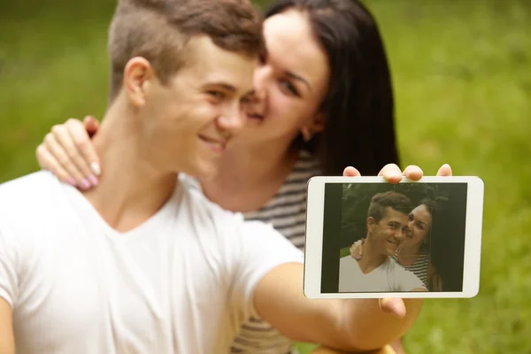 Paar benutzt digitales Tablet und lächelt, während es in der Nähe von E sitzt — Stockfoto