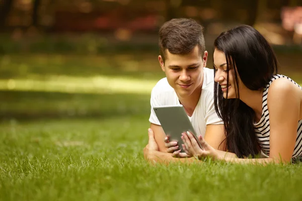 Ehepaar nutzt elektronisches Tablet im Sommerpark — Stockfoto