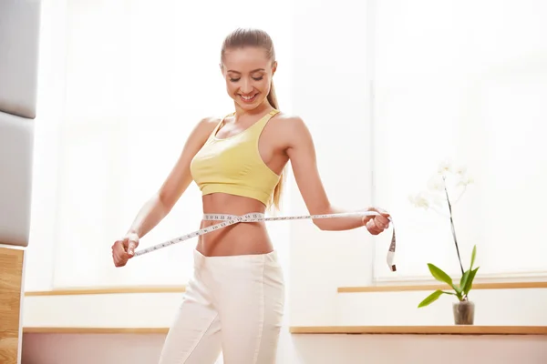 Dieta. Concepto de dieta. Mujer en ropa deportiva midiendo su cintura — Foto de Stock