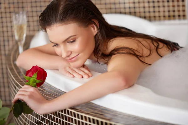 Mulher bonita em banho com rosa. Cuidados corporais . — Fotografia de Stock
