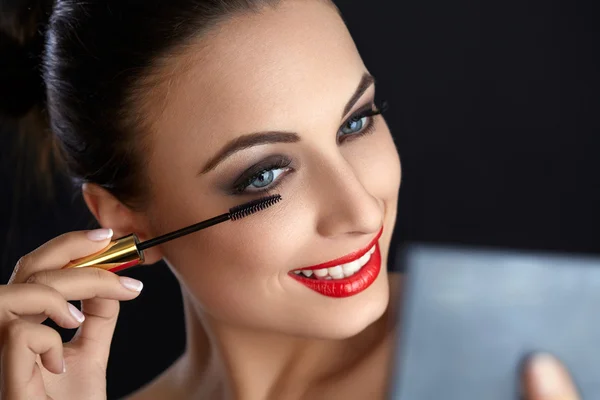 Make-up. schöne Frau beim Make-up. Wimpernbürste. rote Lippen — Stockfoto