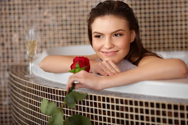 Piękna kobieta w kąpieli z różą. Pielęgnacja ciała. — Zdjęcie stockowe